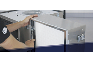 Technician securing a HEPA filter into a commercial-grade air filtration unit using a wrench. Routine maintenance procedure ensures optimal performance in healthcare, cleanroom, and restoration environments by maintaining high-efficiency particle capture.