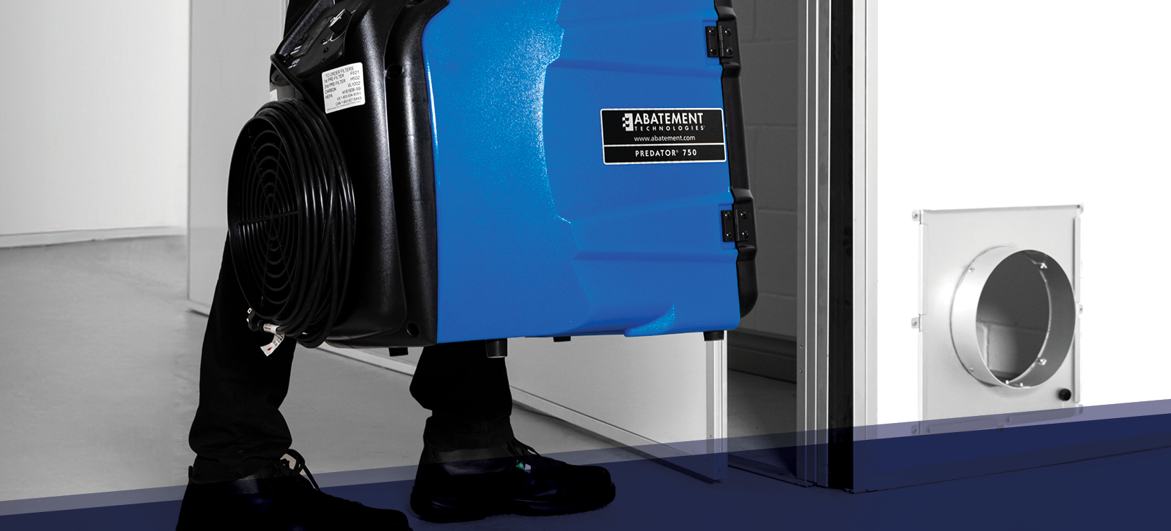 Close-up of a technician deploying the Abatement Technologies PREDATOR 750 portable HEPA air scrubber for negative air containment. Designed for use in restoration, construction, and healthcare settings to control airborne particles and maintain indoor ai